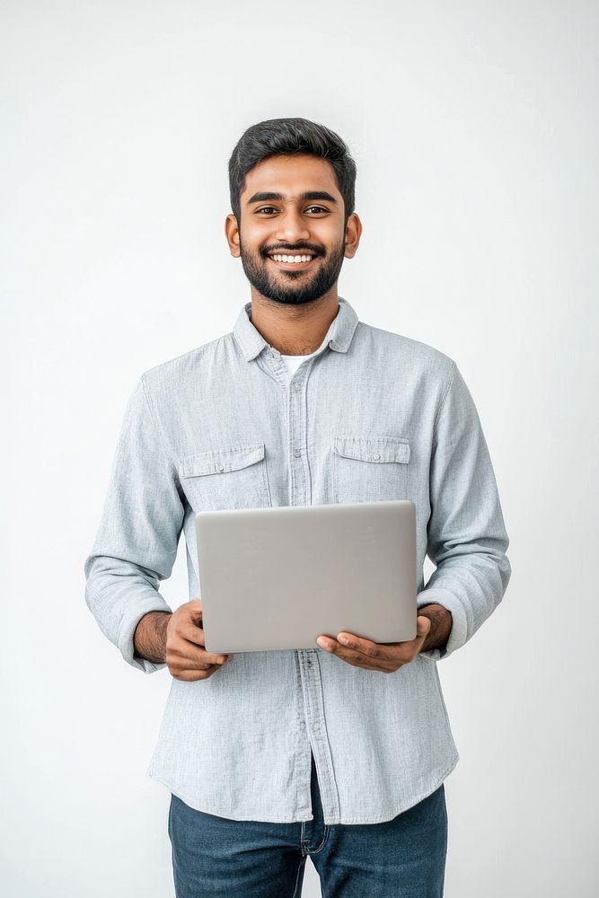 a indain man wearing an oversized shirt laptop standing casual.
